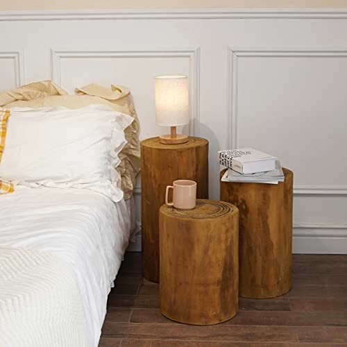 Bedside with wooden tables, lamp, and mug.