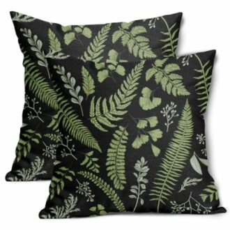 Two black throw pillows with green botanical leaf patterns