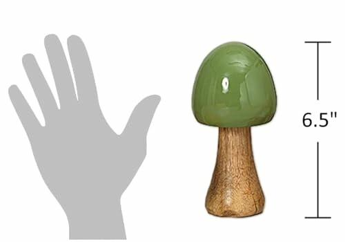 Green ceramic mushroom decor piece next to a hand silhouette for scale.