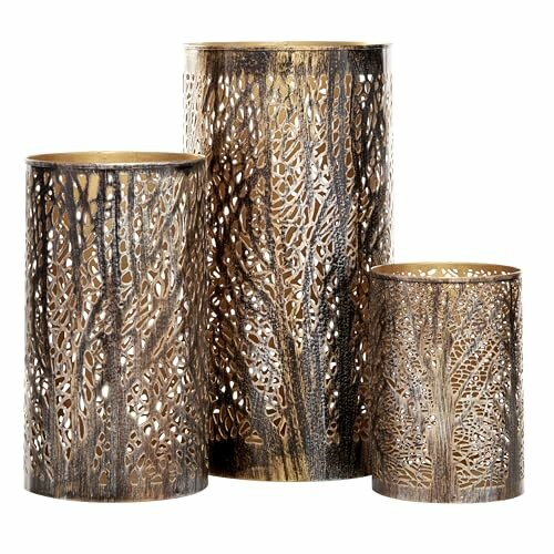 Three decorative metal candle holders with intricate leaf patterns.