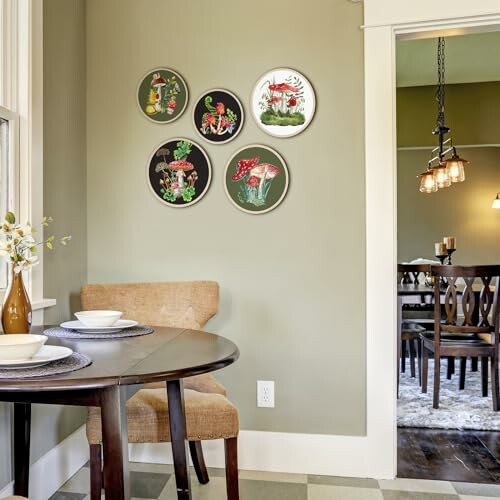 Dining room with decorative plates on green wall and a table with chairs.