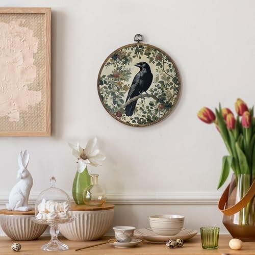 Stylish dining room scene with a crow wall art, tulips, and ceramic tableware.