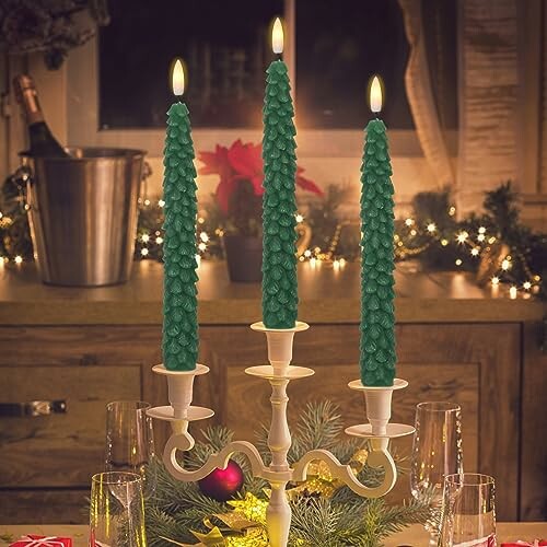 Three green candles on a candelabra with holiday decor