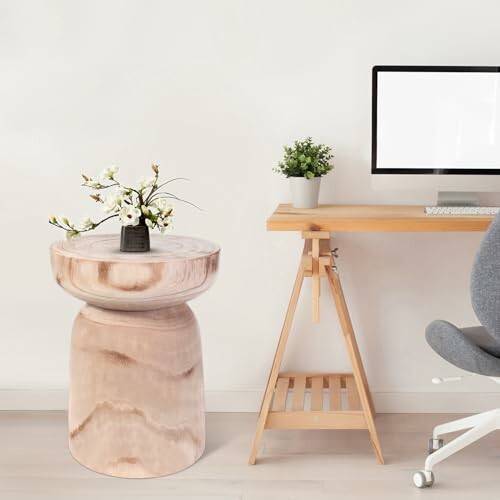 Minimalist home office with wooden desk, chair, and small table with flower vase.