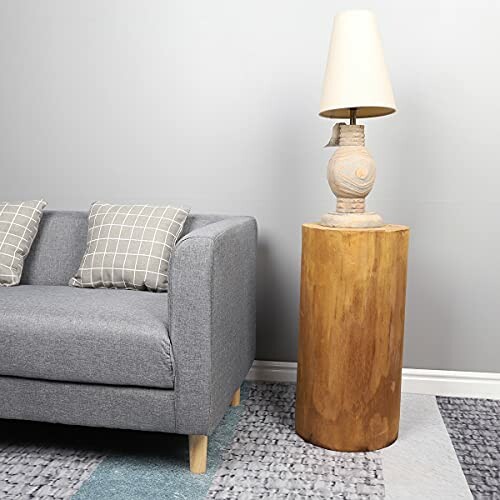 Modern living room with a gray sofa, two checkered cushions, a wooden side table, and a lamp.