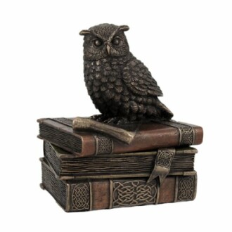 Bronze owl statue perched on stacked books