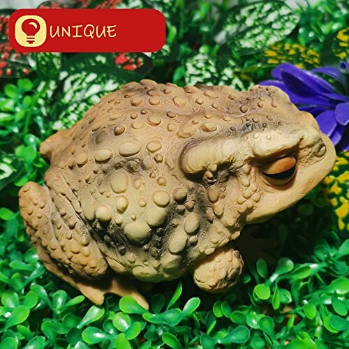 Realistic frog figurine on green leaves.