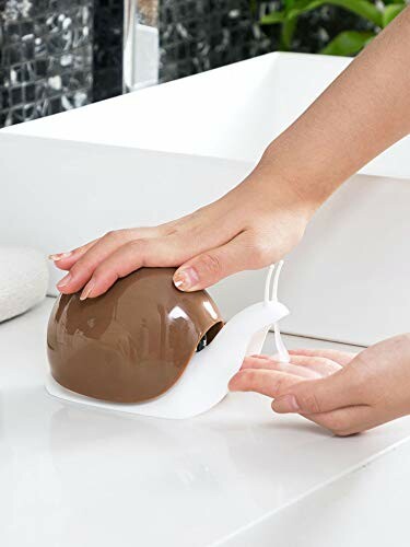 Snail-shaped soap dispenser being used on a sink