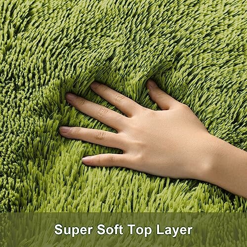 Hand touching soft green rug surface.