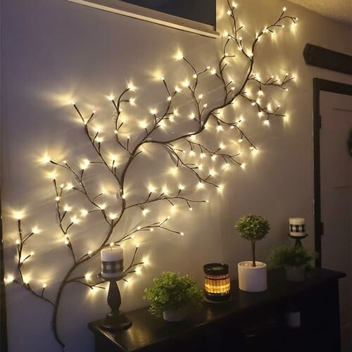 Wall decoration with branch-like string lights and plants on a shelf.