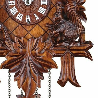 Detail of a wooden cuckoo clock with a squirrel carving.